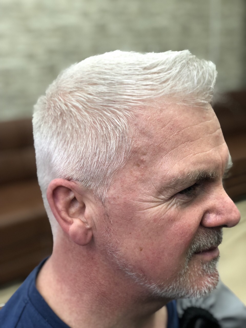 Side view of a finished short haircut on a grey-haired customer at Top Fades